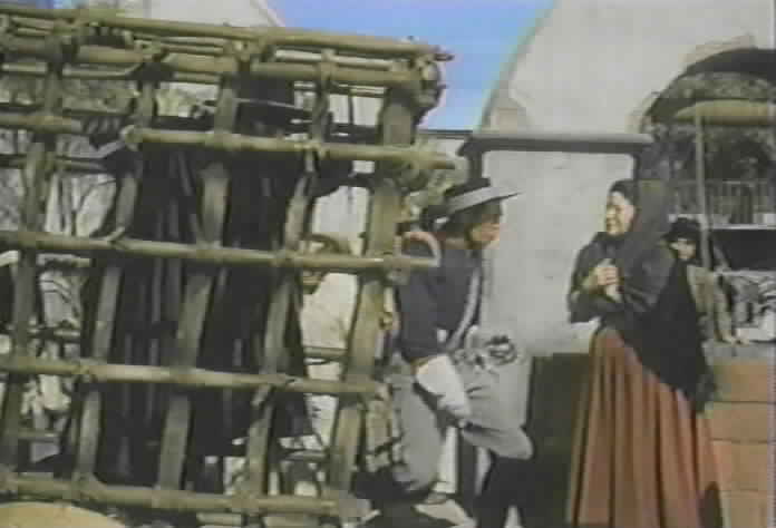 Zorro is brought into the plaza so that the peons can see that he has been captured.
